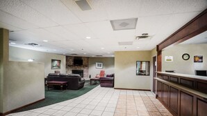 A hotel lobby with a fireplace, seating area, and a reception desk. - Baymont by Wyndham Johnson City (Johnson City)