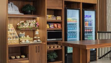 Un interior de madera con estantes llenos de aperitivos, un televisor y un refrigerador.