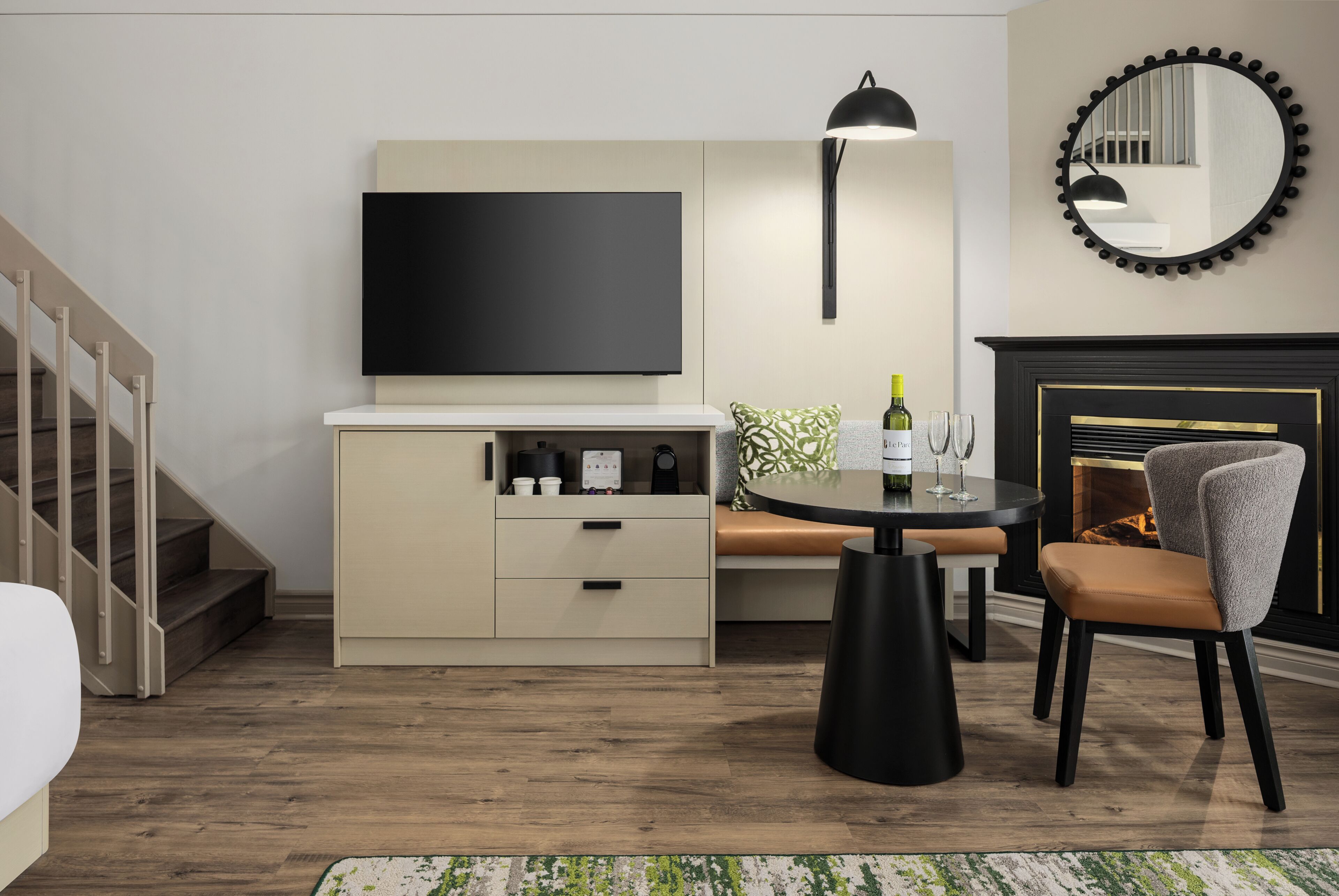 A modern living room with a TV, sofa, dining table, and fireplace.