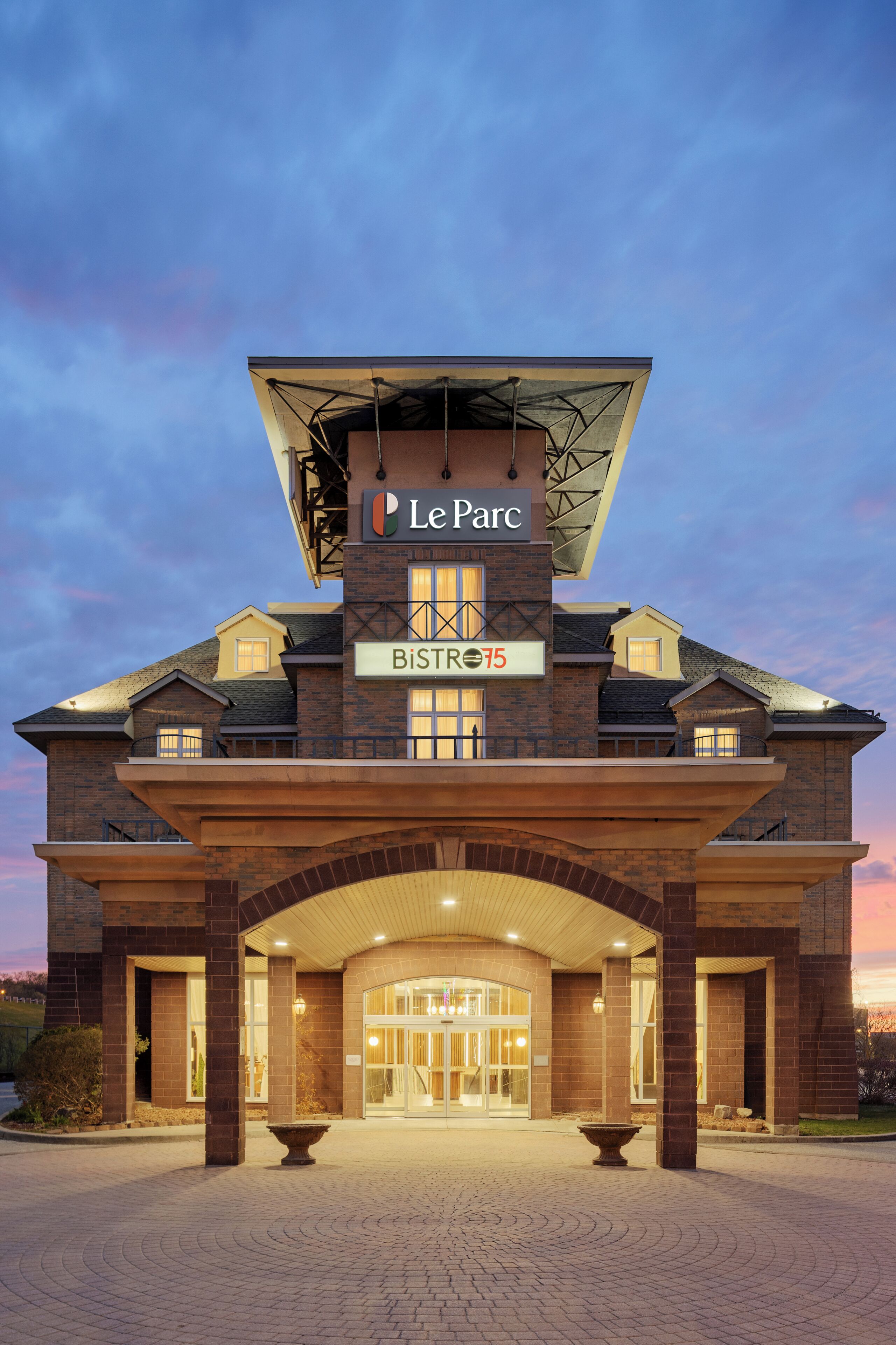 A hotel entrance with a sign reading 'Le Parc' and 'BISTRO 75'.