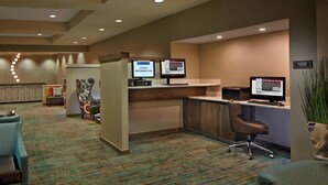 A reception area with a reception desk, two computer monitors, a chair, and a carpeted floor. - Residence Inn by Marriott Hartford Downtown (Hartford)