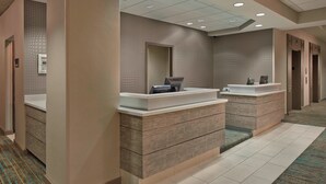 A hotel reception area with a reception desk, a telephone, and a mirror. - Residence Inn by Marriott Hartford Downtown (Hartford)