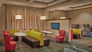 A hotel lobby with seating areas, a flat-screen TV, and a patterned carpet. - Residence Inn by Marriott Hartford Downtown (Hartford)