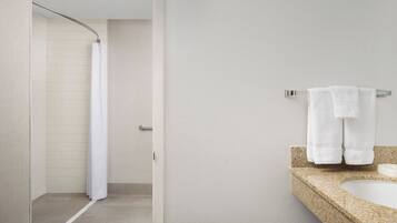 Ein Badezimmer mit Dusche, Waschbecken und Handtuchhalter.