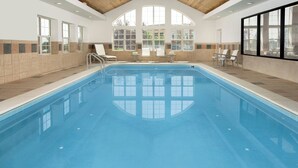 An indoor swimming pool with clear blue water, surrounded by lounge chairs and a view of the outdoors through large windows. - Residence Inn By Marriott Denver Park Meadows (Englewood)