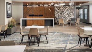 A modern conference room with a wooden reception desk, multiple seating arrangements, and a patterned wall. - Residence Inn By Marriott Denver Park Meadows (Englewood)