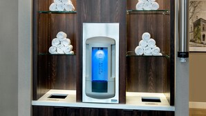 Ein Wasserhahn mit blauem Licht, umgeben von Regalen mit aufgerollten Handtüchern.