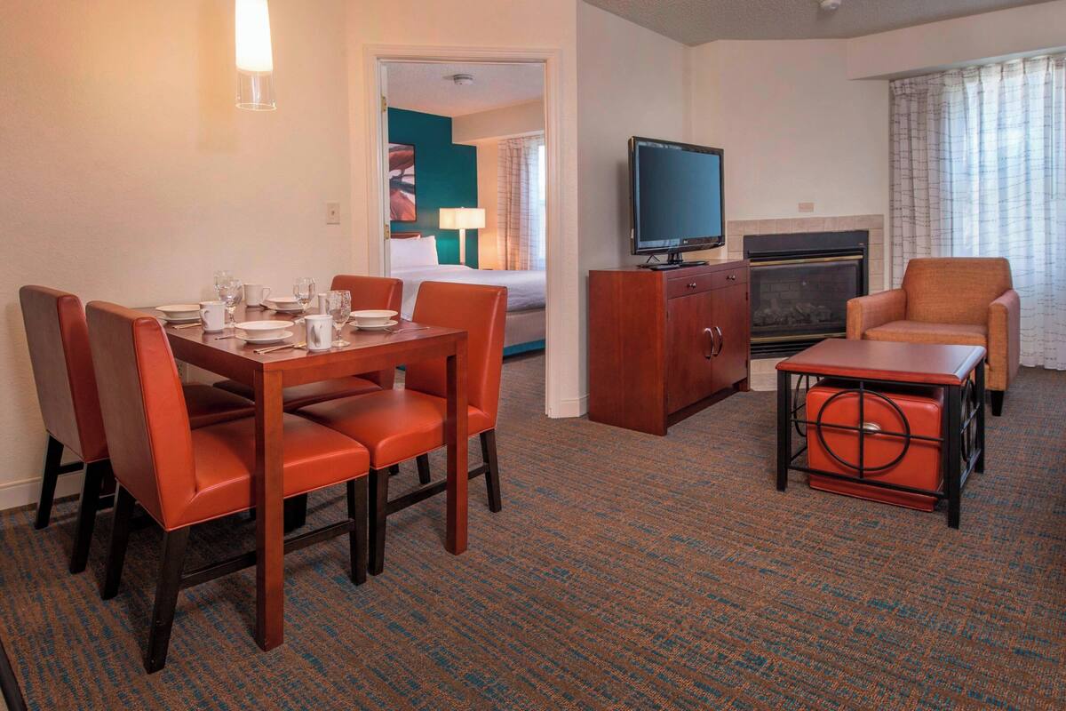 Une chambre d’hôtel comprenant un coin repas, une télévision, une cheminée et un espace salon.