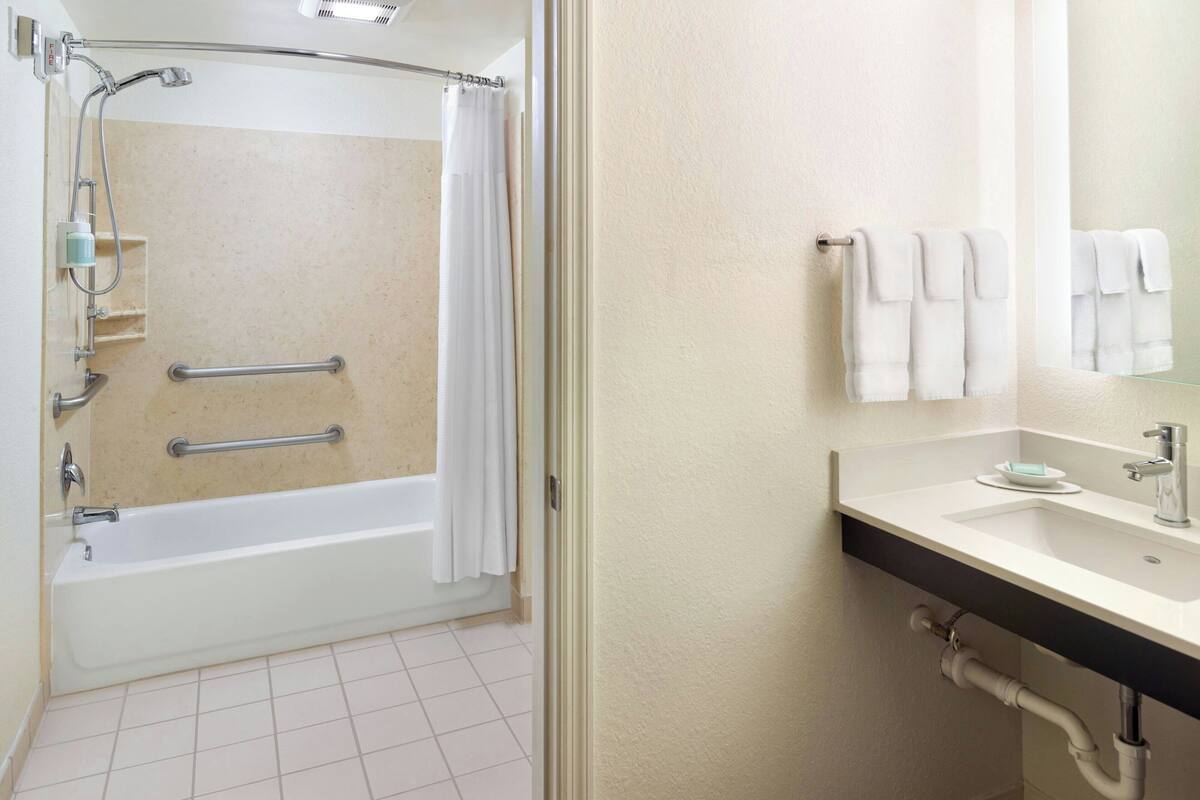 Une salle de bain avec une baignoire, une douche et un lavabo.