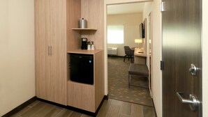 A compact hotel room with a kitchenette, a small refrigerator, a coffee maker, and a flat-screen TV. - Holiday Inn Ciudad Juarez by IHG (Ciudad Juárez)