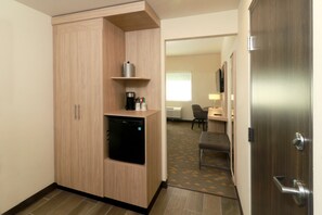 A compact hotel room with a kitchenette, a small refrigerator, a coffee maker, and a flat-screen TV. - Holiday Inn Ciudad Juarez by IHG (Ciudad Juárez)