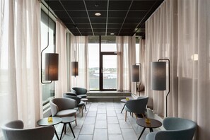 Een moderne zithoek met zitplaatsen en uitzicht op de stad.