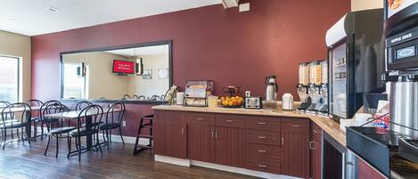 A modern kitchen with a marble countertop, wooden cabinets, and a coffee machine.