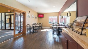 A hotel lobby with a reception desk, seating area, and a bakery display. - Red Roof Inn St Louis - Troy, IL (Troy)