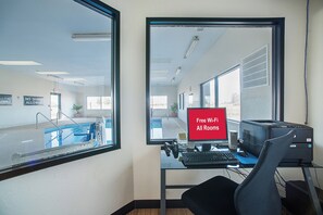 A modern office space with a desk, computer, and a large window. - Red Roof Inn St Louis - Troy, IL (Troy)
