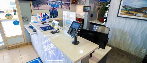 A reception desk with a 'RODEO FUN' sign, a television, and a framed picture of an airplane.