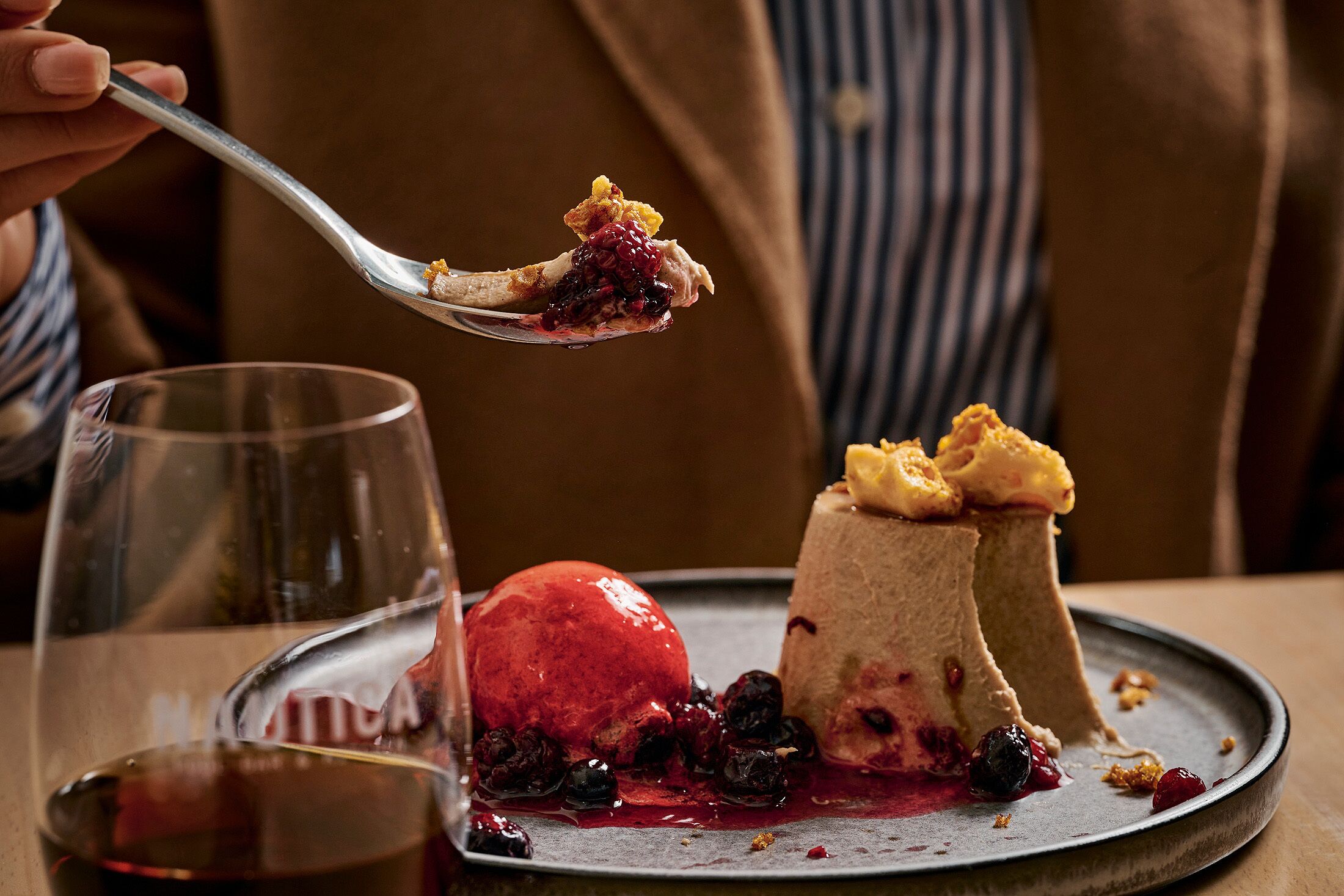 A dessert plate with a scoop of red ice cream, a cake, and berries.