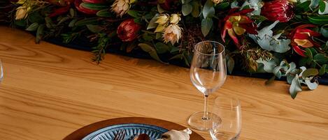 Una mesa de comedor dispuesta con platos, cubiertos y un florero.