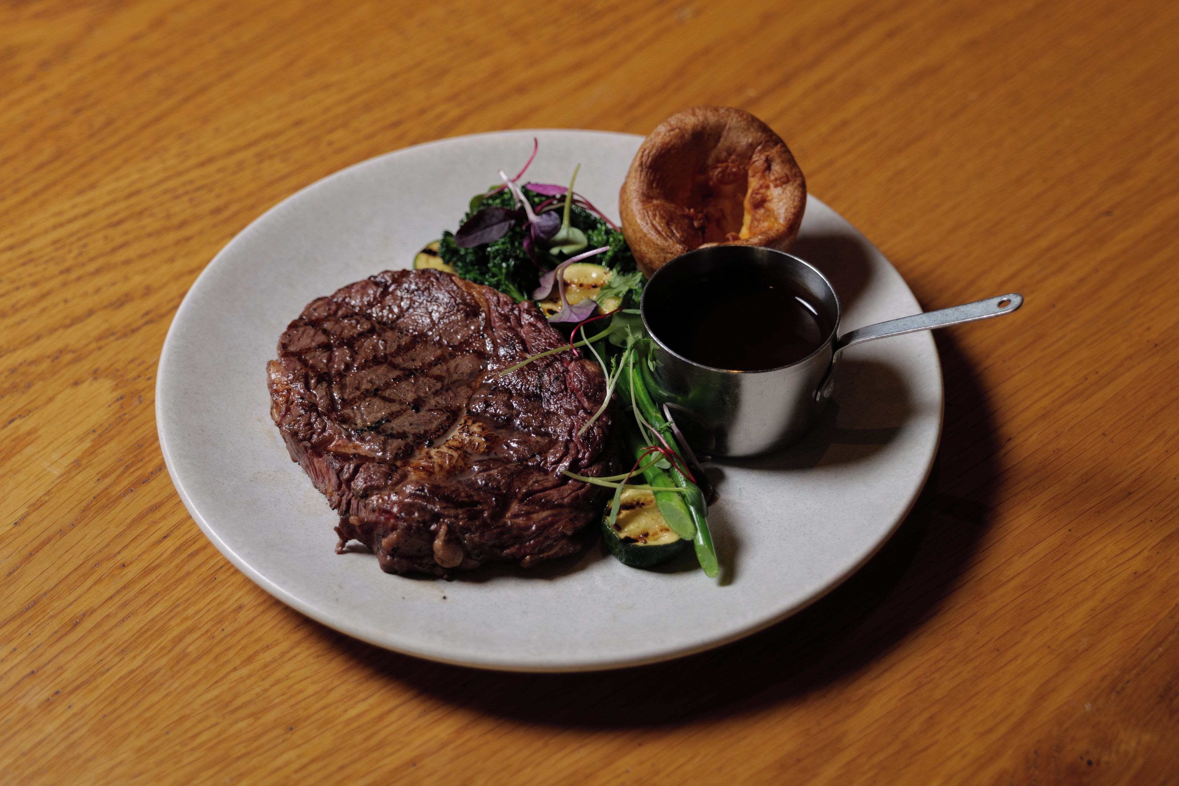 A plate with a steak, Yorkshire pudding, and a side salad.