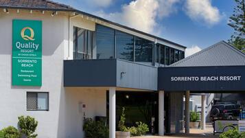 A modern building with a sign for 'Quality Resort by Choice Hotels' and 'Sorrento Beach Resort'.