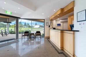 A reception area with a reception desk, chairs, and a view of the outdoors.