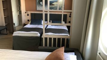Habitación de hotel con dos camas, vista del cielo a través de una ventana y un armario de madera.