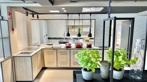 Una cocina moderna con armarios de madera, encimera negra y plantas en macetas.