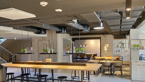 Una cocina moderna con una isla central, taburetes de bar e iluminación colgante.