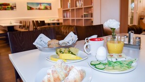 A breakfast setting with croissants, a fruit plate, a glass of orange juice, and a white flower on a table. - Good Morning Mölndal (Mölndal)