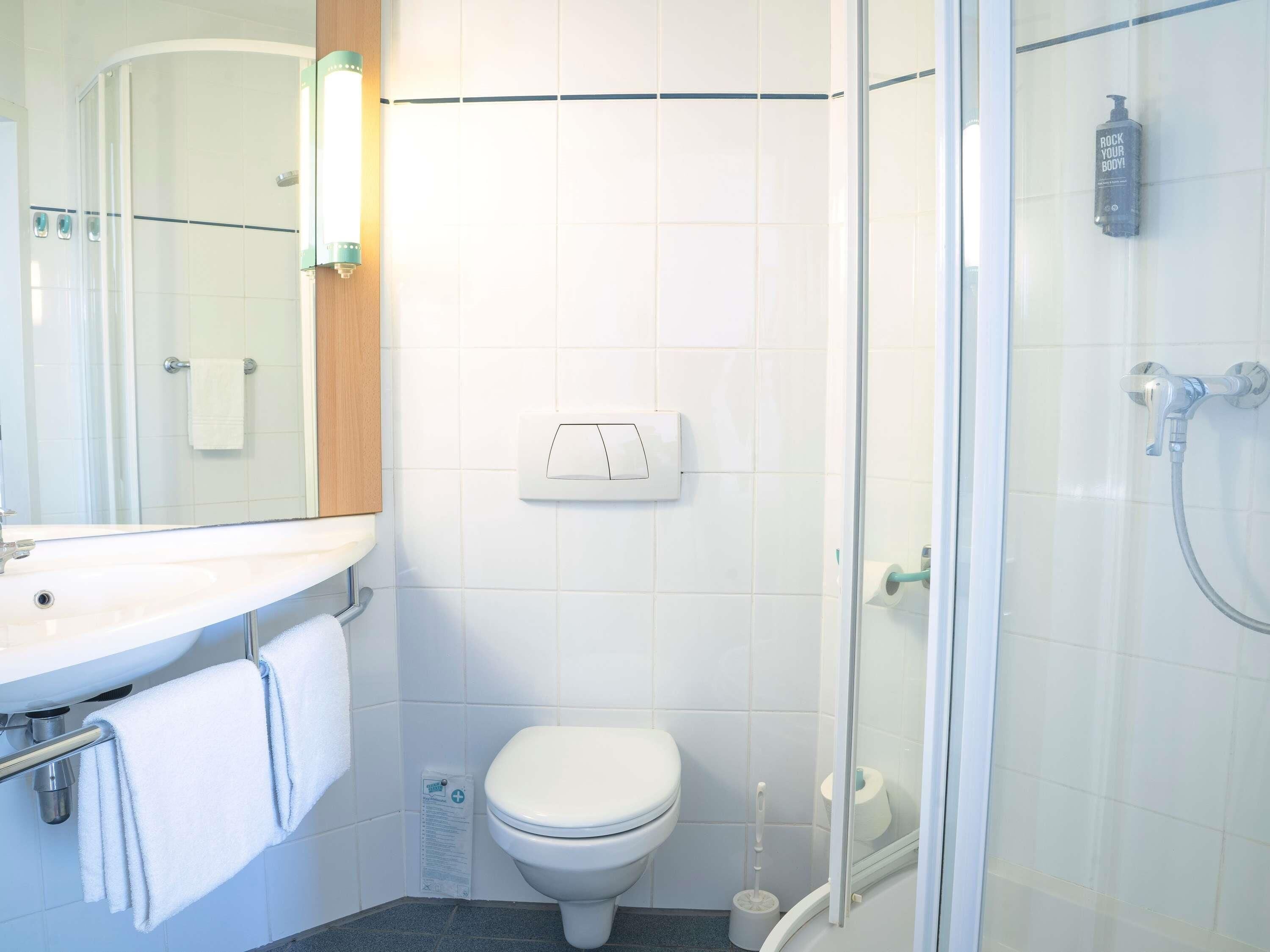Un baño con ducha, inodoro y lavamanos.