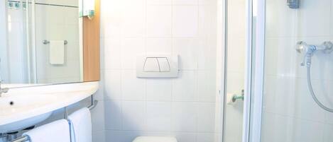 Un baño con ducha, inodoro y lavamanos.