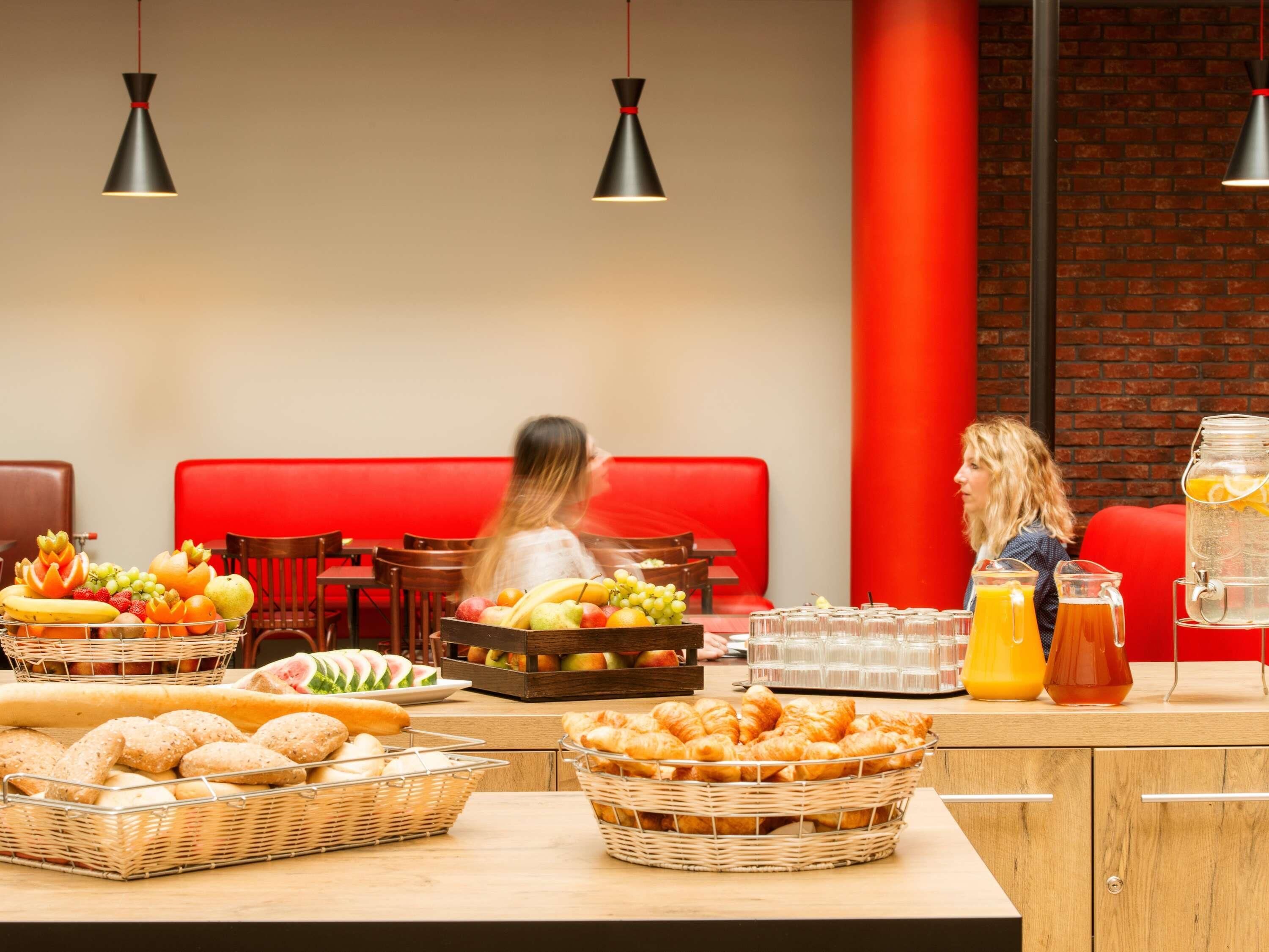 Un bufé de desayuno con diversas frutas, pasteles y bebidas.