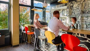 Un bar moderno con techos altos, amplias ventanas y vistas a montañas.