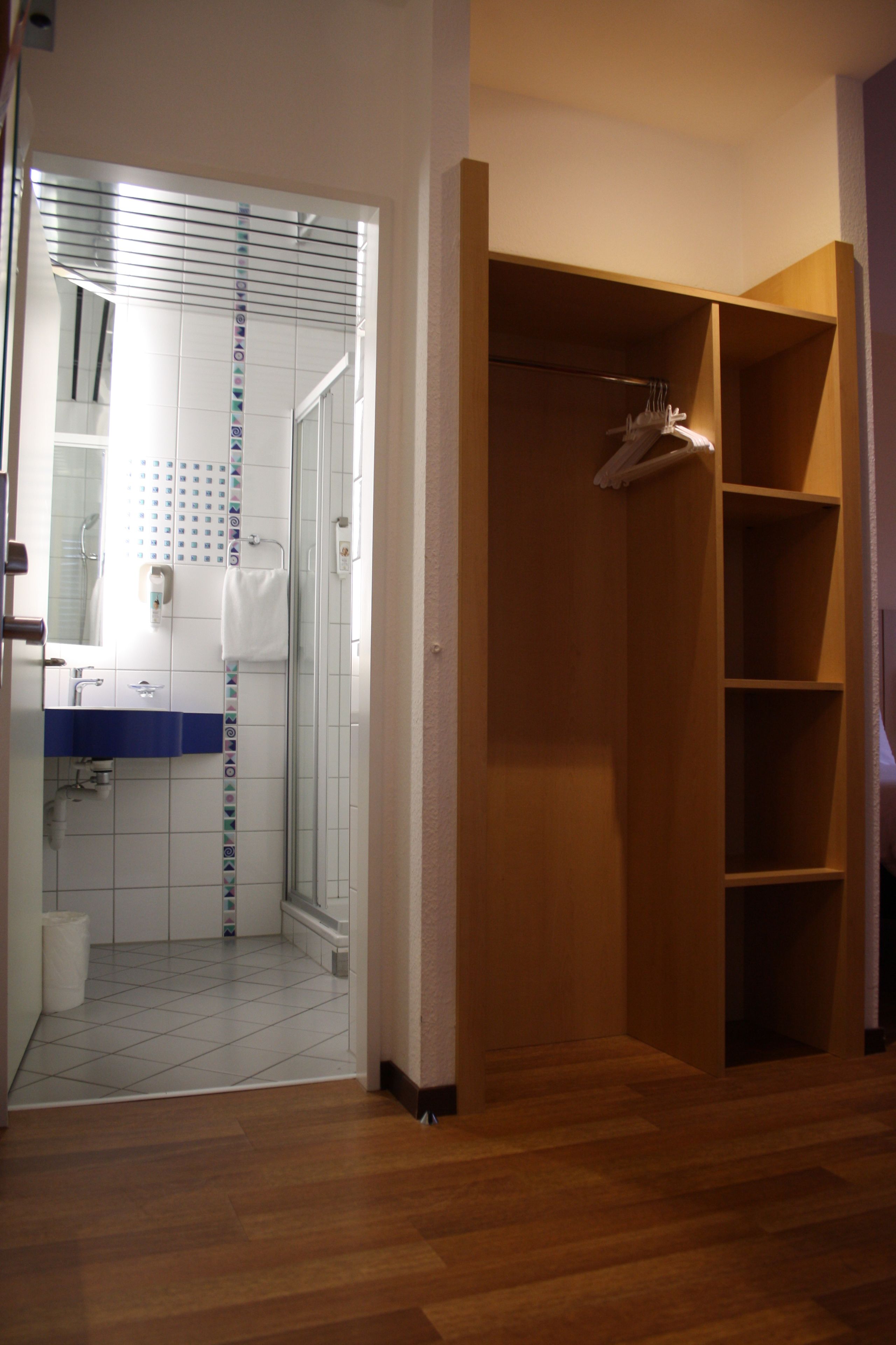 A walk-in closet with wooden shelving and a hanging rack.