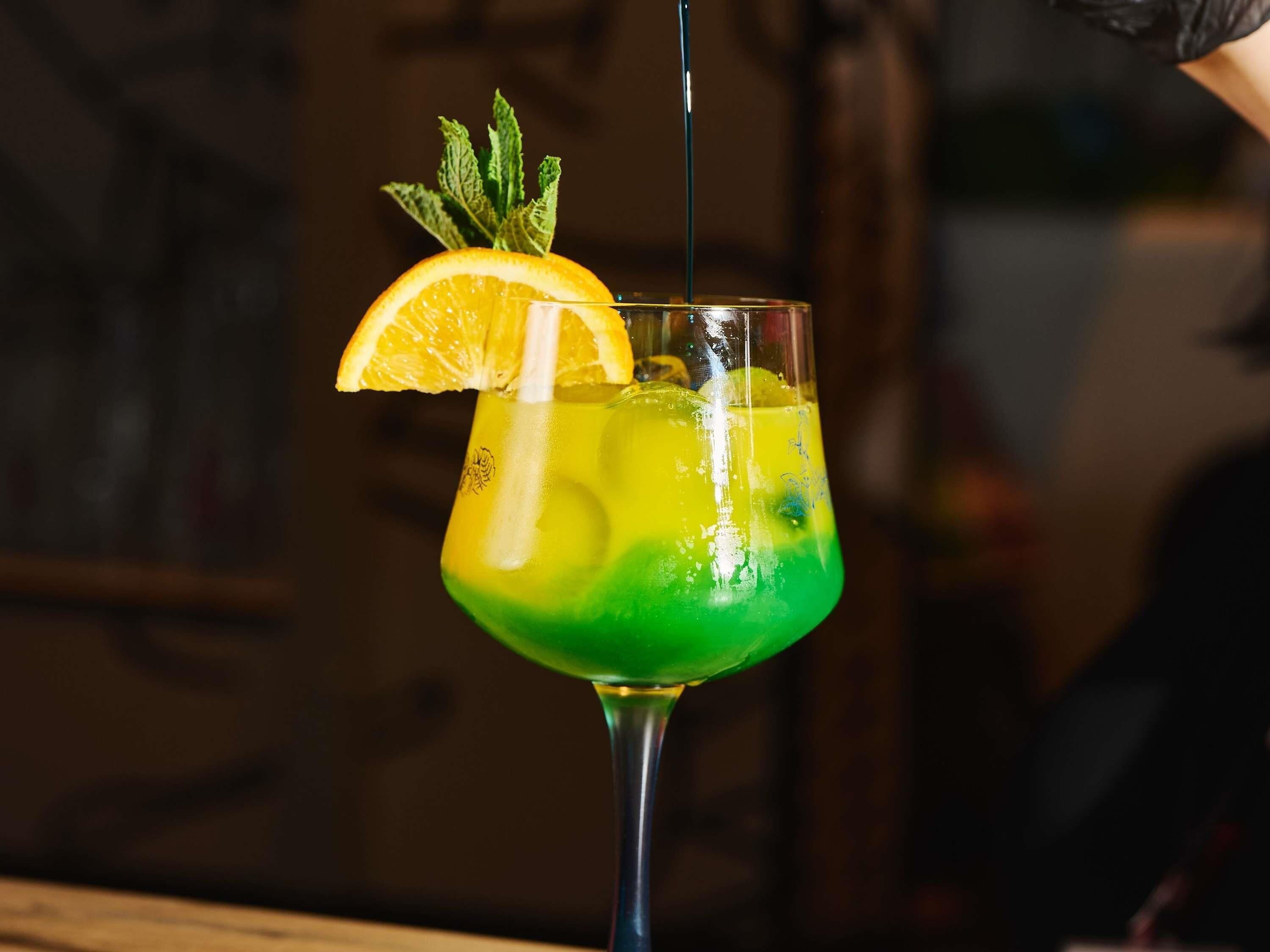 A cocktail with a lime wedge garnish, served in a stemmed glass.