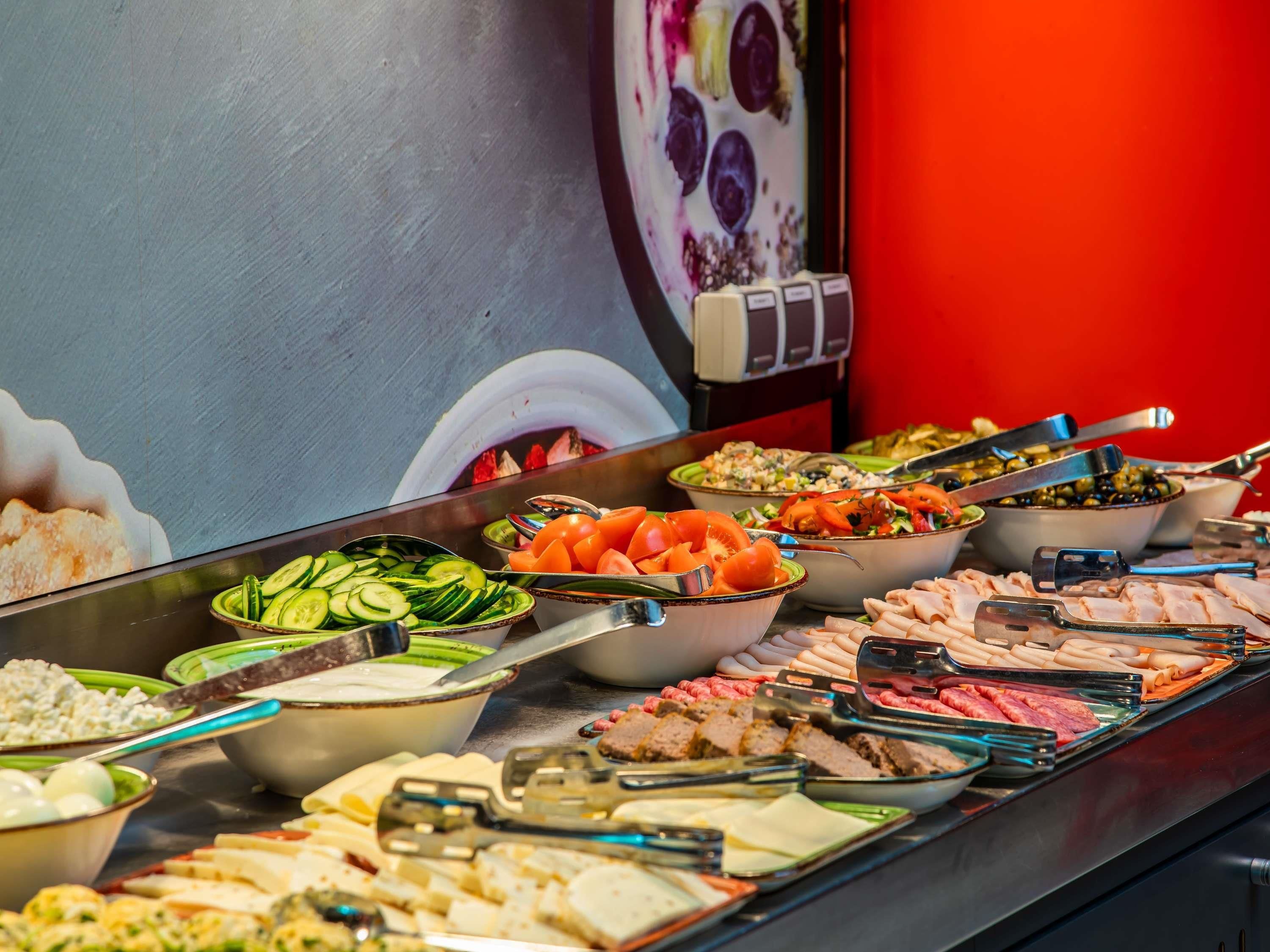 A buffet with various food options including salads, meats, and cheeses.