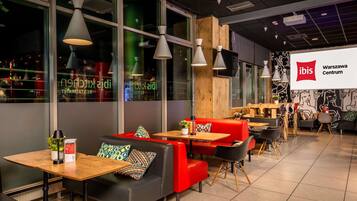 A modern interior with seating areas, tables, and a large window.