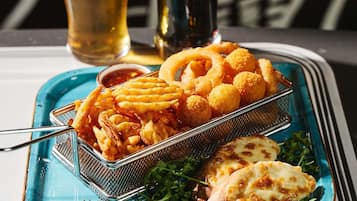 Una bandeja con comida frita, una jarra de cerveza y una botella.