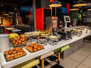 A buffet setup with various food items, including pastries, fruits, and a coffee machine. - ibis Warszawa Centrum (Warsaw)