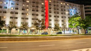 A hotel with a prominent red sign, multiple windows, and a modern architectural design. - ibis Warszawa Centrum (Warsaw)