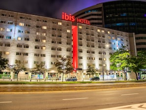 A hotel with a prominent red sign, multiple windows, and a modern architectural design. - ibis Warszawa Centrum (Warsaw)
