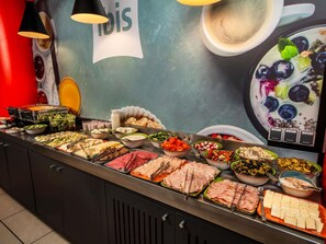 Un bufé con diferentes opciones de comida, incluyendo carnes, quesos y ensaladas.