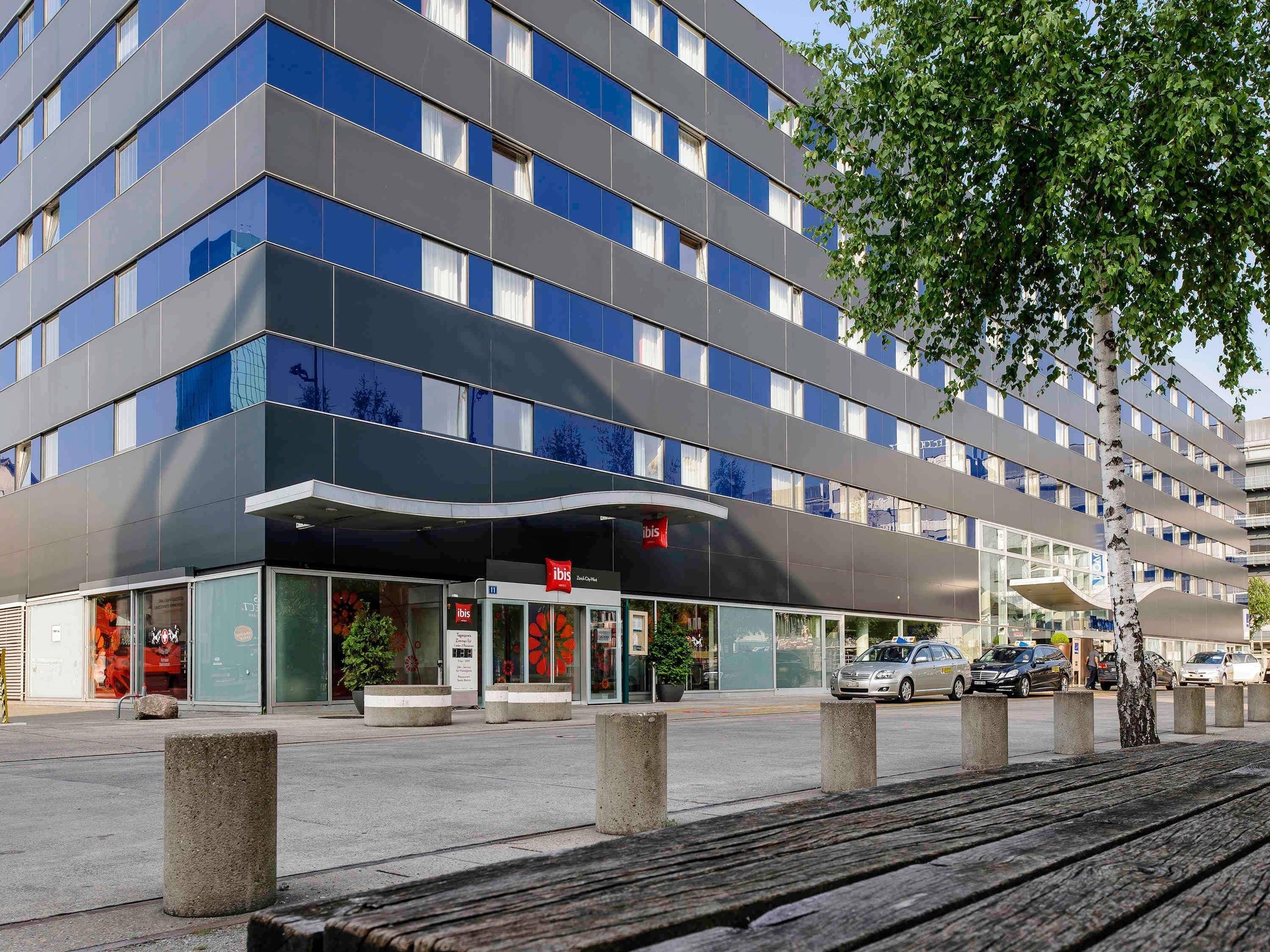 A modern hotel with a flat facade, large windows, and a prominent entrance.