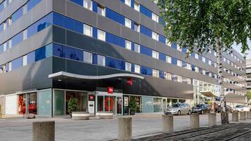 A modern hotel with a flat facade, large windows, and a prominent entrance.