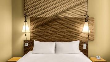 Ein Hotelzimmer mit einem Bett, zwei Nachttischen, einem Kopfteil mit strukturierter Musterung und zwei Wandlampen.
