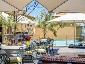 Una piscina al aire libre, sombrillas, sillones reclinables de piscina