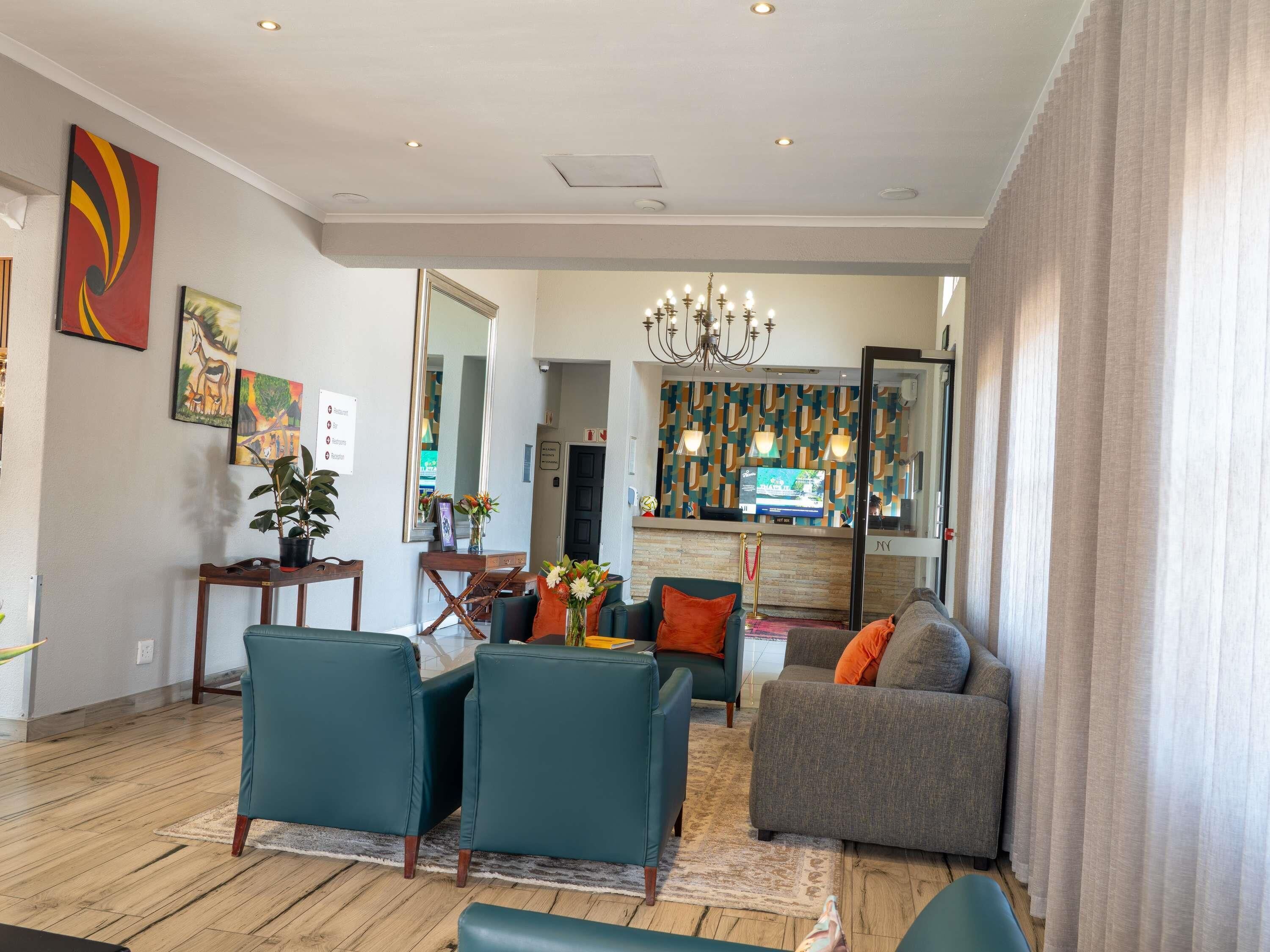 Una sala de estar moderna con un sofá, sillas, una mesa de centro y un televisor.