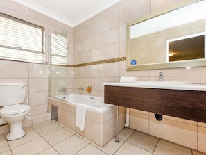 A bathroom with a toilet, bathtub, and sink. - Mercure Johannesburg Bedfordview Hotel (Germiston)