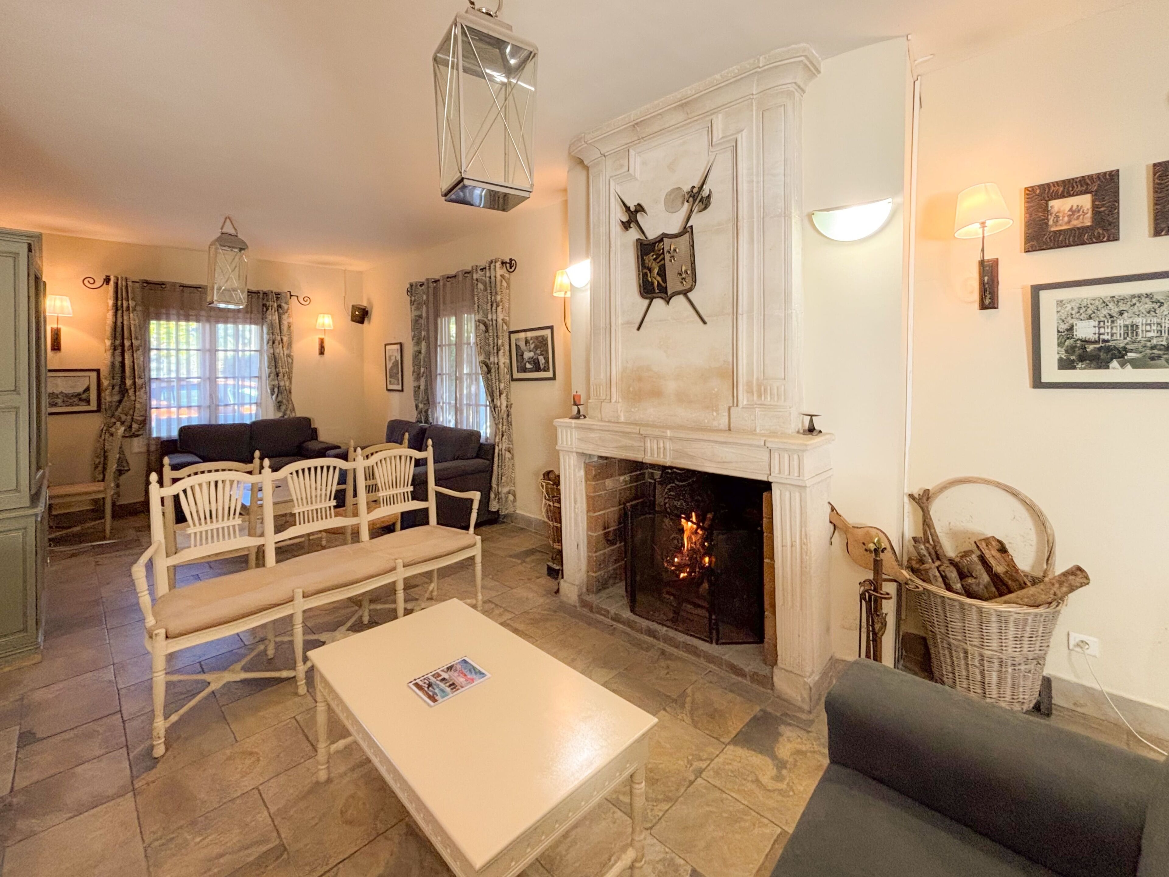 A living room with a fireplace, seating, and a dining area.