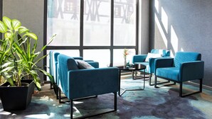 A modern living room with blue armchairs, a coffee table, and a potted plant. - ACHAT Hotel Heppenheim (Heppenheim)